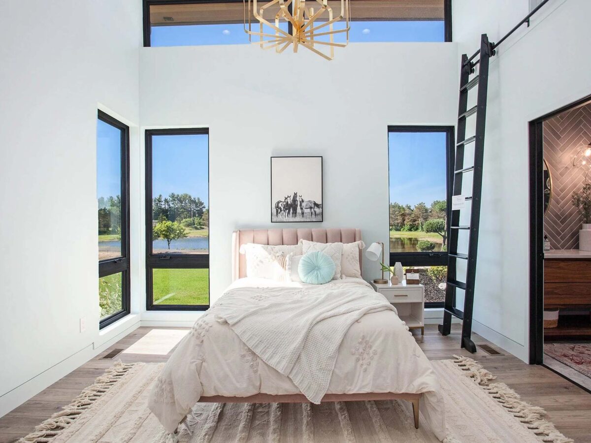Open master bedroom with many windows facing the backyard