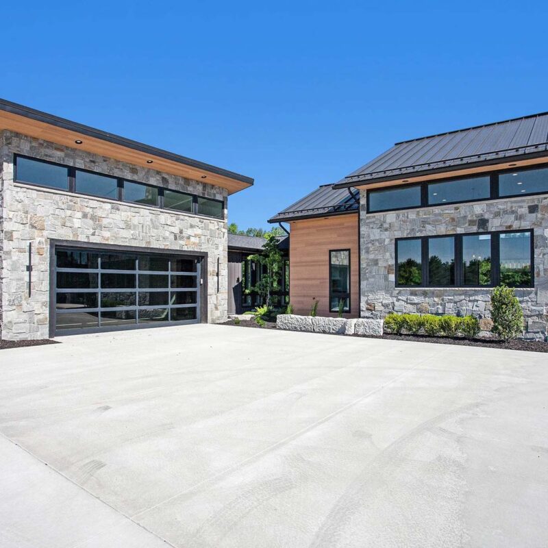 Modern luxury industrial home with grey stone and warm oak accents