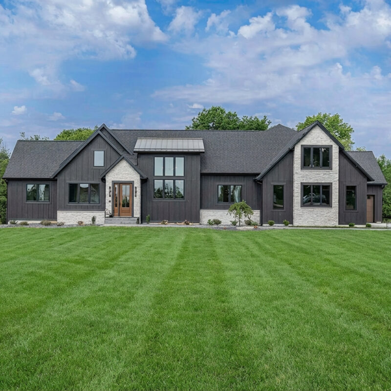 Luxury new black home with a green yard