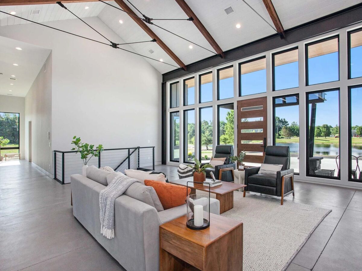 Industrial open space living room with a wall of windows facing the backyard